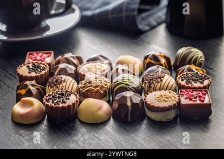 Mescolare praline al cioccolato su un tavolo nero. Foto Stock