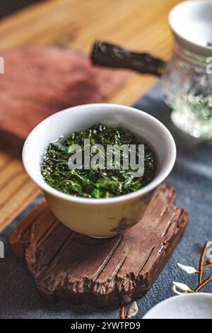 Goditi una rinfrescante infusione di tè verde servita in una tazza tradizionale splendidamente realizzata Foto Stock