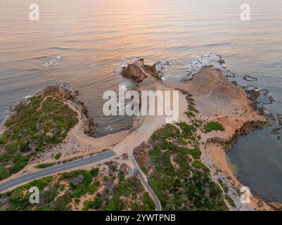 Vista aerea di una strada che conduce a un parcheggio auto lungo una costa frastagliata a Robe, nell'Australia meridionale Foto Stock