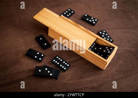 una scatola di piastrelle a domino su un tavolo di legno Foto Stock