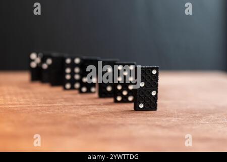 set di piastrelle in domino bianco e nero in ordine su tavolo in legno - effetto domino concetto - Foto Stock