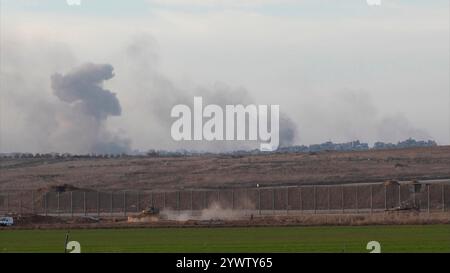 CONFINE con GAZA, ISRAELE - 10 DICEMBRE: Un carro armato israeliano rotola lungo il confine con Gaza come un massiccio flusso di fumo dopo il bombardamento israeliano nella parte settentrionale di Gaza, nel mezzo delle continue battaglie tra Israele e il gruppo militante Hamas il 10 dicembre 2024 al confine con Gaza, Israele. Foto Stock