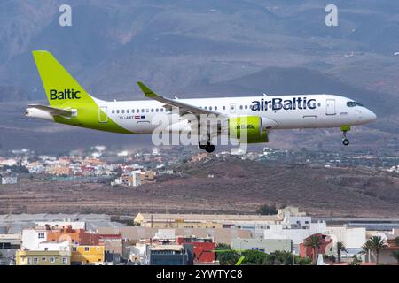 Moderno Airbus A220 della compagnia aerea Air Baltic che atterra all'aeroporto di Gran Canaria, Gando, con la montagna sullo sfondo. Foto Stock