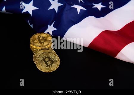 Una pila di monete d'oro con la lettera B su di esse è posta accanto a una bandiera americana Foto Stock