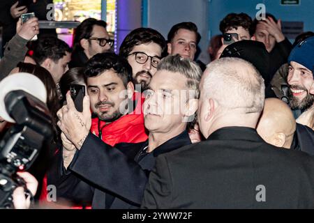 NLD, Amsterdam, 10-12-2024: Robbie Williams scatta selfie con i fan durante la visita alla prima del film Better Man al Royal Theatre Tuschinski di Amsterdam. ANP / Hollandse Hoogte / Patrick Harderwijk netherlands Out - belgium Out Foto Stock