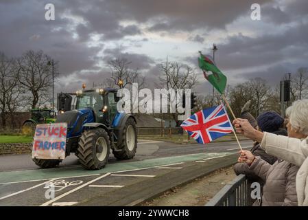 I sostenitori ondeggiano le bandiere mentre i trattori sfilano a York, dando voce alle preoccupazioni per i nuovi cambiamenti fiscali governativi che colpiscono gli agricoltori. Foto Stock