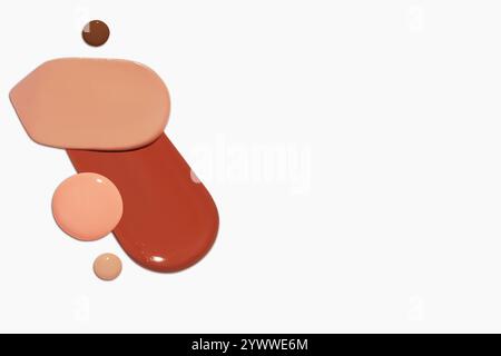 Composizione di strisci e gocce di fondamento liquido in varie tonalità, tra cui toni chiari e scuri, isolati su uno sfondo chiaro. Foto Stock