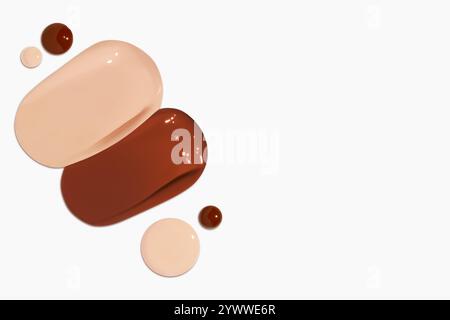 Composizione di strisci e gocce di fondamento liquido in varie tonalità, tra cui toni chiari e scuri, isolati su uno sfondo chiaro. Foto Stock