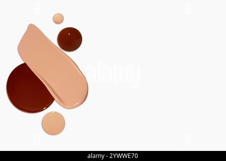 Composizione di strisci e gocce di fondamento liquido in varie tonalità, tra cui toni chiari e scuri, isolati su uno sfondo chiaro. Foto Stock