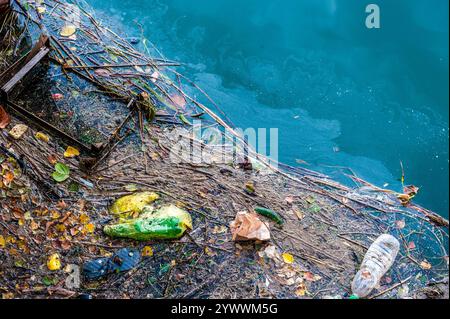 Inquinamento idrico vecchi rifiuti e macchie di petrolio sulla superficie del fiume Foto Stock