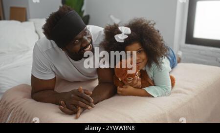 Padre e figlia si godono momenti di qualità insieme in un'accogliente camera da letto con calore e amore. Foto Stock