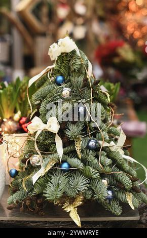 Albero di Natale in miniatura decorato con coni, archi e palle Foto Stock
