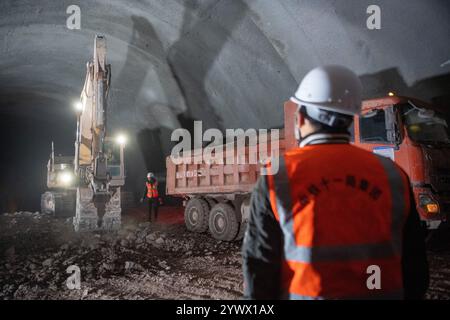 Chongqing. 12 dicembre 2024. I membri del personale lavorano nel cantiere del tunnel di Shipingcun sulla ferrovia ad alta velocità di Chengdu-Dazhou-Wanzhou, nella municipalità di Chongqing del sud-ovest della Cina, il 12 dicembre 2024. Il tunnel di Shipingcun, lungo 1.889 metri, è stato perforato con successo giovedì. Crediti: Tang Yi/Xinhua/Alamy Live News Foto Stock