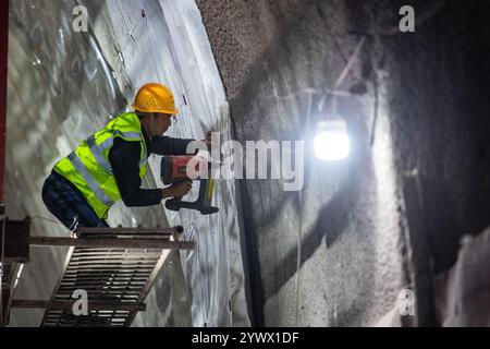 (241212) -- CHONGQING, 12 dicembre 2024 (Xinhua) -- Un membro del personale lavora nel cantiere del tunnel Shipingcun sulla ferrovia ad alta velocità Chengdu-Dazhou-Wanzhou nel comune di Chongqing della Cina sud-occidentale, 12 dicembre 2024. Il tunnel di Shipingcun, lungo 1.889 metri, è stato perforato con successo giovedì. (Xinhua/Tang Yi) Foto Stock