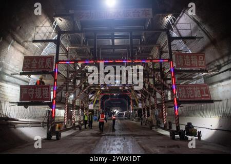 (241212) -- CHONGQING, 12 dicembre 2024 (Xinhua) -- i membri del personale lavorano nel cantiere del tunnel Shipingcun sulla ferrovia ad alta velocità Chengdu-Dazhou-Wanzhou nel comune di Chongqing della Cina sud-occidentale, 12 dicembre 2024. Il tunnel di Shipingcun, lungo 1.889 metri, è stato perforato con successo giovedì. (Xinhua/Tang Yi) Foto Stock