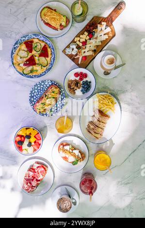 Il brunch include vari panini aperti, omelette, Macedonia di frutta, yogurt con muesli e bevande rinfrescanti. Foto Stock