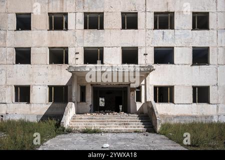 Ingresso a un edificio residenziale abbandonato e distrutto, vecchi appartamenti sovietici nella città fantasma, Engilchek, Tian Shan, Kirghizistan, Asia Foto Stock