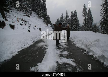 Srinagar, India. 12 dicembre 2024. Nevicate fresche a Heerpora Shopify nel sud del Kashmir. Le persone camminano mentre i ragazzi giocano con la neve dopo una nevicata fresca. (Foto di Nisar UL Haq Allaie/Pacific Press) credito: Pacific Press Media Production Corp./Alamy Live News Foto Stock