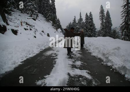 Srinagar, Jammu e Kashmir, India. 12 dicembre 2024. Nevicate fresche a Heerpora Shopify nel sud del Kashmir. Le persone camminano mentre i ragazzi giocano con la neve dopo una nevicata fresca. (Immagine di credito: © Nisar UL Haq Allaie/Pacific Press via ZUMA Press Wire) SOLO PER USO EDITORIALE! Non per USO commerciale! Foto Stock