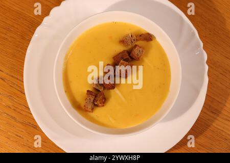 Deliziosa zuppa cremosa di zucca servita calda e splendidamente guarnita con crostini croccanti Foto Stock