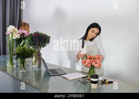 La fiorista Bruna organizza fiori vivaci mentre gestisce le sue piccole attività aziendali. Foto Stock