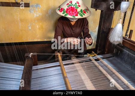 Vietnam, Hoi An, 2024-02-19, città vecchia, telaio di tessitura, seta, artigianato, abiti tradizionali, cappello di paglia vietnamita, fotografia di Jean-Yves Bardin Foto Stock