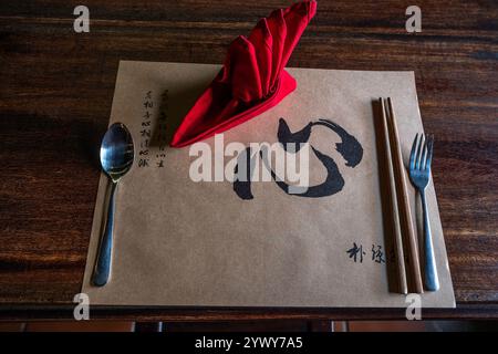 Vietnam, Hoi An, 2024-02-19, città vecchia, ristorante, placemat, posate, tovagliolo rosso, carattere cinese, bacchette, design, minimalista, decorazione, Photog Foto Stock