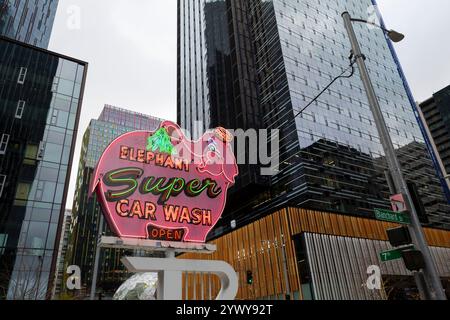 Il cartello Elephant Car Wash, un amato punto di riferimento locale, è annidato tra gli edifici del quartier generale Amazon presso la torre Amazon Nitro South nel Triangolo Denny di Seattle Foto Stock