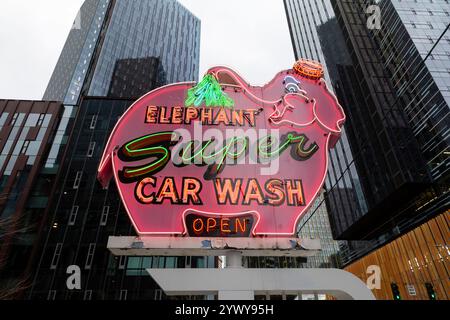 Il cartello Elephant Car Wash, un amato punto di riferimento locale, è annidato tra gli edifici del quartier generale Amazon presso la torre Amazon Nitro South nel Triangolo Denny di Seattle Foto Stock
