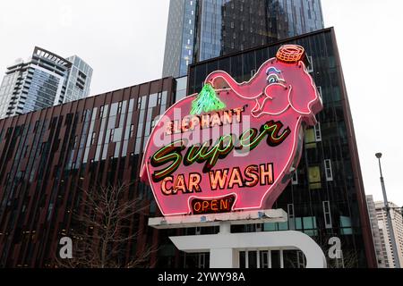Il cartello Elephant Car Wash, un amato punto di riferimento locale, è annidato tra gli edifici del quartier generale Amazon presso la torre Amazon Nitro South nel Triangolo Denny di Seattle Foto Stock