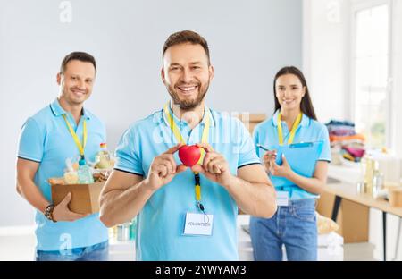 Ritratto del volontario che tiene il cuore rosso nel Centro umanitario Foto Stock