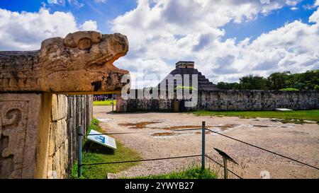 Scultura della testa del Serpente Kukulcan da vicino con vista della grande Piramide di Kukulcan, El Castillo a Chichen Itza, Messico Foto Stock