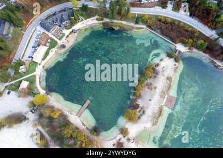 Prospettiva aerea mozzafiato del lago jasna, immerso nel vibrante fogliame autunnale in slovenia, con le sue acque cristalline e turchesi Foto Stock
