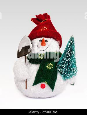 Statuetta giocattolo pupazzo di neve con una pala e un albero di Natale Foto Stock