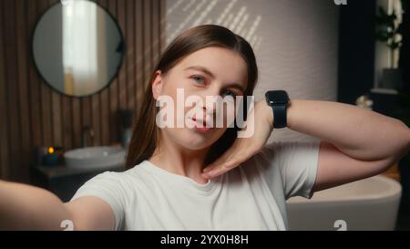 Donna caucasica beauty blogger vlogger modello influencer selfie foto cellulare social media SkinCare blog vlog in casa bagno spensierato felice Foto Stock