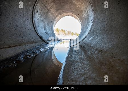 All'interno di un canale di drenaggio circolare in calcestruzzo con un triclo d'acqua Foto Stock