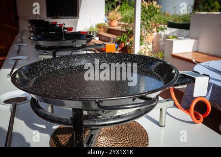 Una paellera si appoggia su un bruciatore a gas, in attesa di ingredienti freschi. Questa iconica paella, al centro dell'autentica paella, viene utilizzata per la paella valenciana, un simbolo Foto Stock