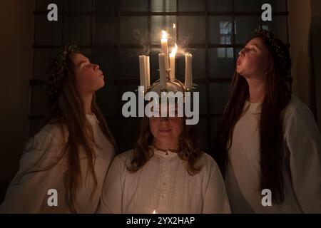 Londra, Regno Unito. 12 dicembre 2024. Sankta Lucia celebra la chiesa di San Giorgio a Bloomsbury. Jessica Paton del London Nordic Choir ha la sua corona di candele spenta dopo un concerto di successo, basato sul coraggio e il martirio di una giovane ragazza siciliana Santa Lucia (Lucia di Siracusa 283-304). L'ottavo concerto annuale di Sankta Lucia e Natale del London Nordic Choir è noto per le vivaci esibizioni di repertorio a cappella con la passione per la musica corale scandinava. Direttore musicale: Carina Einarson. Crediti: Guy Corbishley/Alamy Live News Foto Stock