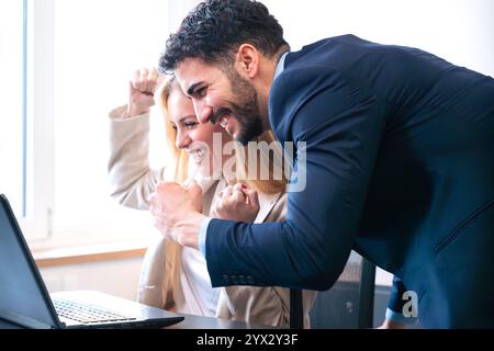 Un team aziendale entusiasta che celebra il successo in Office Environment Foto Stock