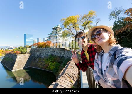 Una giovane coppia di viaggiatori si fa un selfie al Castello di Osaka, il Castello di Osaka è uno dei luoghi di interesse più famosi del Giappone e di Osaka, lo stile di vita delle vacanze. Foto Stock