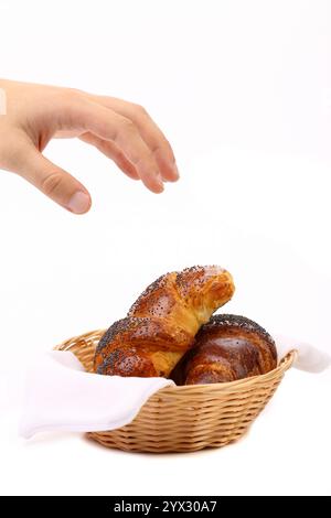 Mano sopra i croissant nel cestino. Sfondo bianco. Foto Stock