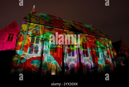 Una vista di fantastici racconti e dove trovarli, un'installazione di luci e suoni di Luxmuralis proiettata sulle rovine storiche dell'Abbazia di St Augustine e della King's School di Canterbury, Kent, che fa parte del Canterbury Arts Festival. Lo spettacolo è stato creato dalla pluripremiata collaborazione artistica dello scultore Peter Walker e del compositore David Harper. Data foto: Giovedì 12 dicembre 2024. Foto Stock