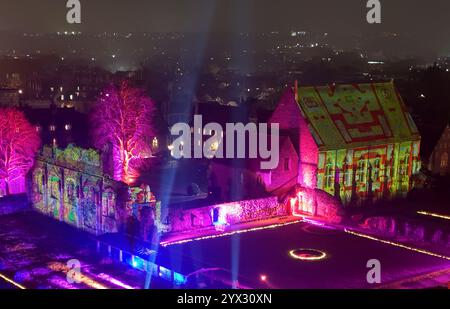 Una vista di fantastici racconti e dove trovarli, un'installazione di luci e suoni di Luxmuralis proiettata sulle rovine storiche dell'Abbazia di St Augustine e della King's School di Canterbury, Kent, che fa parte del Canterbury Arts Festival. Lo spettacolo è stato creato dalla pluripremiata collaborazione artistica dello scultore Peter Walker e del compositore David Harper. Data foto: Giovedì 12 dicembre 2024. Foto Stock