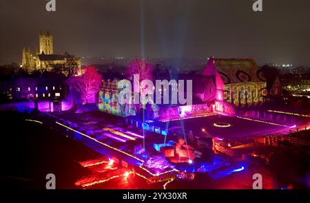 Una vista di fantastici racconti e dove trovarli, un'installazione di luci e suoni di Luxmuralis proiettata sulle rovine storiche dell'Abbazia di St Augustine e della King's School di Canterbury, Kent, che fa parte del Canterbury Arts Festival. Lo spettacolo è stato creato dalla pluripremiata collaborazione artistica dello scultore Peter Walker e del compositore David Harper. Data foto: Giovedì 12 dicembre 2024. Foto Stock