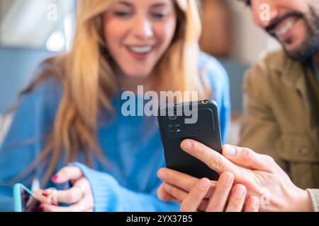 Primo piano di una coppia che si gode un momento mentre guarda uno smartphone Foto Stock