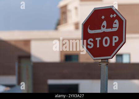 Segnale stradale DI STOP, in arabo, su sfondo sfocato Foto Stock