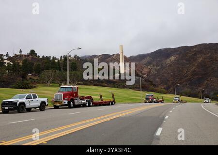 Malibu, California, U.S.A. 12 dicembre 2024. La monumentale croce, detta anche Pillar of Pepperdine, si erge nettamente bianca contro le montagne carbonizzate che bruciavano dietro di essa e gran parte delle colline della Pepperdine University durante l'incendio di Malibu, che era contenuto solo il 7% il 12 dicembre 2024. I camion antincendio CAL di Los Angeles in primo piano sono pronti a proteggere gli studenti e le strutture. (Immagine di credito: © Amy Katz/ZUMA Press Wire) SOLO PER USO EDITORIALE! Non per USO commerciale! Crediti: ZUMA Press, Inc./Alamy Live News Foto Stock