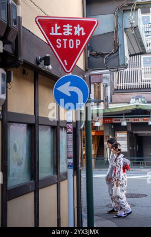 Una giovane coppia cammina lungo una strada a Kyoto. Foto Stock