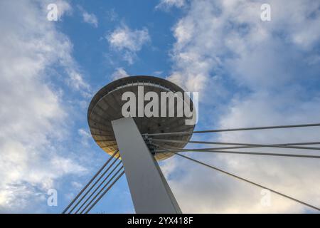 Una vista dall'angolo basso della Torre UFO sul Ponte SNP di Bratislava contro un cielo dinamico Foto Stock