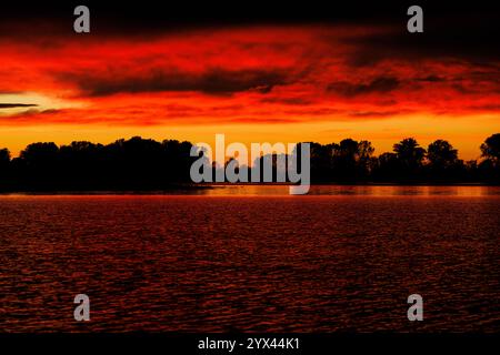 Tramonto arancione nuvoloso sul fiume Mincio a Mantova Foto Stock